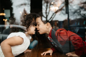 siblings touching noses through window of a coffee shop | coffee shops in vancouver wa