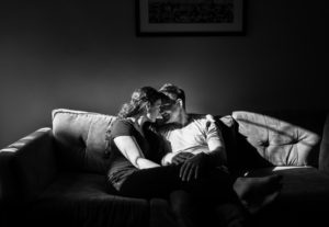 black and white image of couple on couch for in-home family photo shoot 