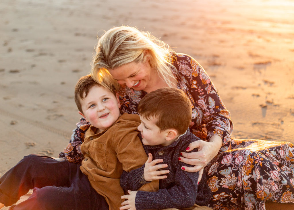 Spas in Cannon Beach | Mom with sons watching sunset in front of Haystack rock in cannon beach