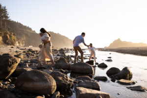 Family walking on rocks on the beach with Oregon Coast Photographer.
