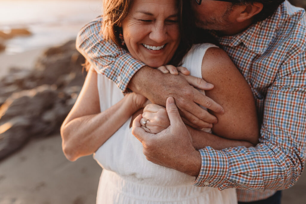 Couple sharing a hug during their beach photo session.