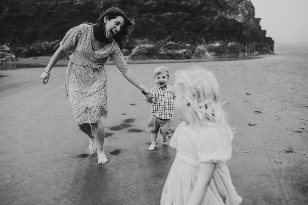 Mother playing with her children during a candid family photography session on the Oregon Coast.