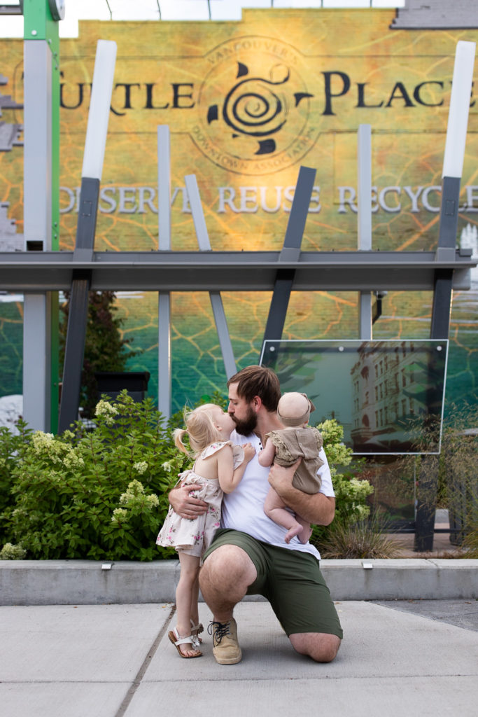 restaurants waterfront vancouver | dad kneeling down kissing young daughter in downtown vancouver Washington 