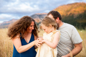 family of three in the Columbia River Gorge playing in a field. 