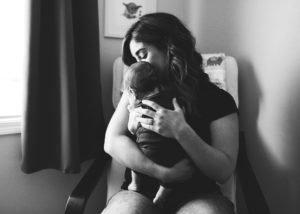 black and white image of mom holding newborn son.