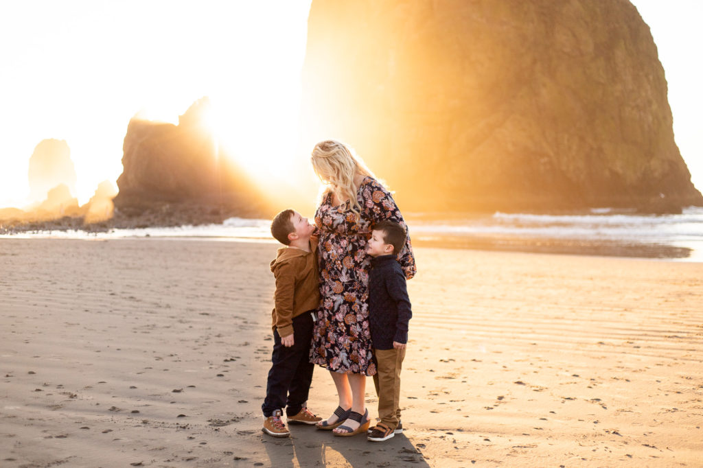 Spas in Cannon Beach | Mom with sons watching sunset in front of Haystack rock in cannon beach