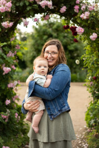 Mother and baby boy standing under rose arch in the Fort Vancouver Garden | Pediatric dentist Vancouver, Wa 