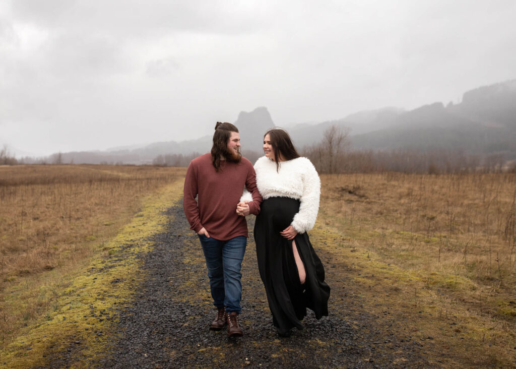 Parents to be holding hands in the columbia river gorge | Portland Midwifery 