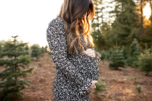 Portland prenatal massage | Mom to be holding belly in evening sunlight. 