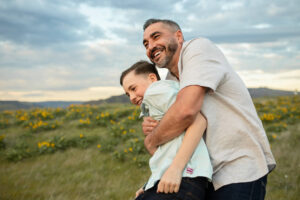 Dad and son hugging in flower field in the Columbia River Gorge area. 