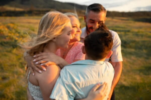 Family of four embracing in the sunset at Rowena Crest, Oregon, in the springtime. 