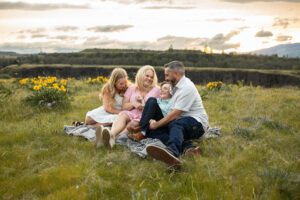family of four sitting on gray blanket at Rowena Crest, Oregon in the spring.