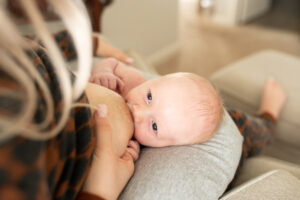Mom breastfeeding her newborn in a chair. Portland lactation consultants