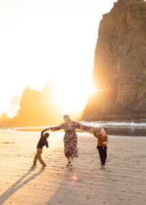 Mom and two sons walking in front of Haystack Rock in Cannon Beach. Things to do in the Oregon coast.