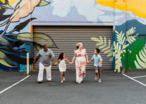 Family of four running in front of mural near Portland, Oregon. 