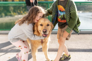 Golden retriever on ferry from Orcas Island with little kids hugging her. 