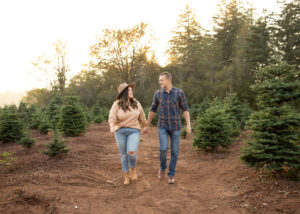 Husband and wife walking through tree farm in PNW area. 