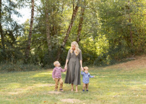 A mom walking hand in hand with her young sons in a park near Portland, Oregon. 