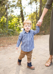 Toddler boy with strawberry blonde hair walking in a park near Portland, Oregon. 