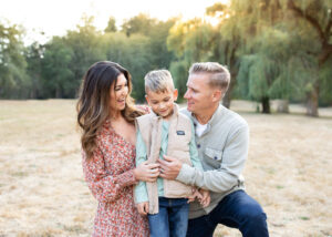 Parents laughing with their son in the park with beautiful willow trees near Portland, Oregon. Portland photographer mini session. 