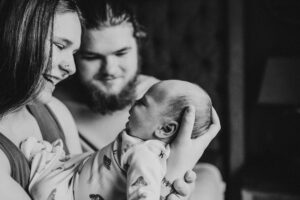 black and white image of new parents doting over newborn son. Portland baby photographer 