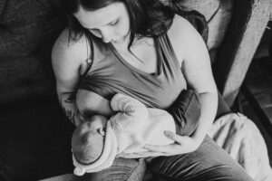 Black and white image of a mother nursing her newborn son. Portland baby photographer.