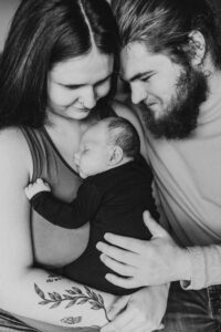 Black and white image of parents holding newborn son. Portland baby photographer. 