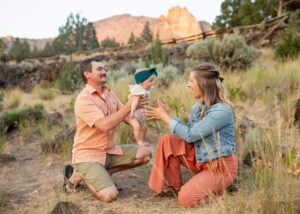 Dad passes the infant to the mother at Smith Rock State Park. 