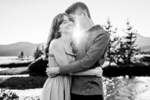 Black and white image of a couple embracing with sunburst between them near Bend, Oregon. 