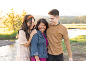 Mother with grown children embracing while laughing in Bend, Oregon. 