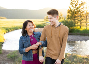 Mother and grown son walking with arms locked in a stunning meadow for a family photo shoot in Bend, Oregon. Things to do in Bend, Oregon in Summer. 