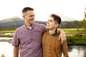 Father and son laughing in a beautful meadow near Sparks Lake, Oregon. 