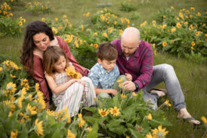 Family of four sitting in a meadow of yellow wildflowers in Hood River, Oregon. 