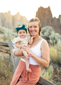 Mother with a baby girl sitting on the fence at Smith Rock State Park, Oregon. Things to do in Bend, Oregon, with kids. 