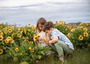 Siblings exploring wildflowers in Hood River, Oregon. Hood River Waterfront Park.