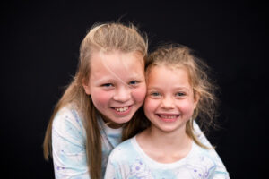 Sibling sister photo for school picture day with black background. 