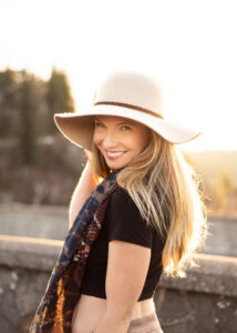 Blonde woman with sunset behind her holding her hat near Portland, Oregon. Portland Branding Photographer.