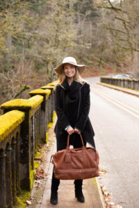 A woman in the Columbia River Gorge bridge with a large brown handbag. 