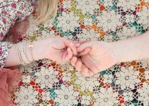 Mom and daughters hands on top of a lace blanket for Joshua Tree family photos.