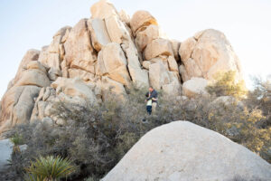 Dad and son atop rugged terrain in the desert during Joshua Tree family photos.