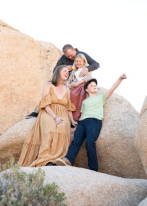 Family of four sitting on rocks at Joshua Tree National Park.