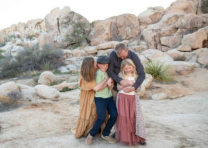 Family hugging and laughing in Socal desert. 