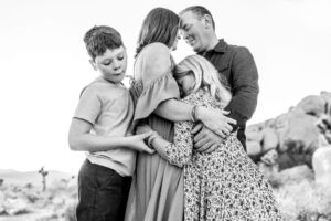 Black and white image of family embracing at Joshua Tree for family photos. 