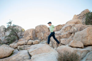 Boy running across rocks in Joshua tree for family photos. 