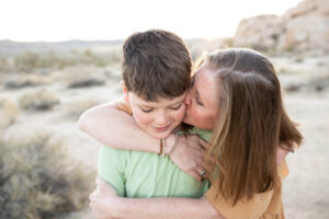 Mom kissing son on cheek at Joshua Tree National Park.