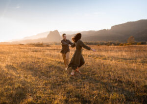 Couple running in a field near Beacon Rock during winter family photos.