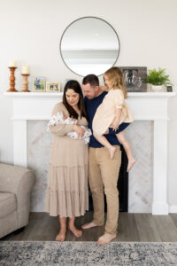 Newborn Photo Idea, family standing in front of fireplace.