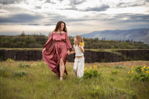 Mom and daughter walking in a field of wildflowers at Rowena Crest. Oregon.