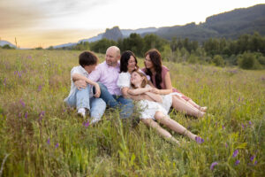 Relaxed family sitting in a spring meadow in the Gorge, showing a calm and natural Portland photography location for spring