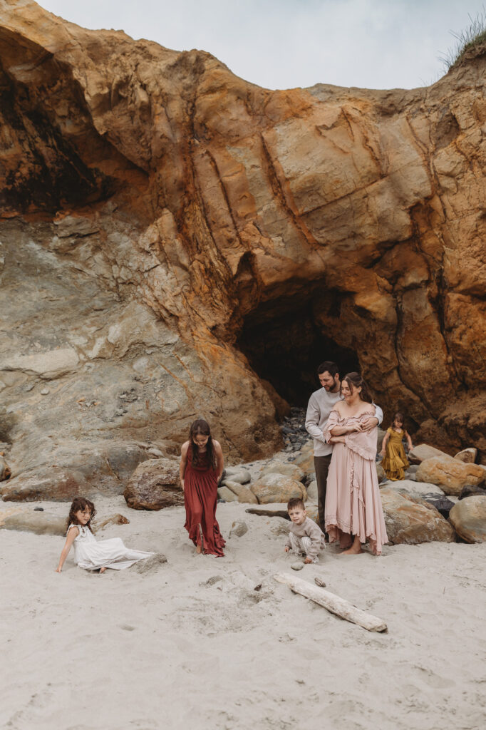Family with young children exploring the Oregon Coast shoreline together.